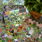 Jigsaw puzzle box with a colorful village scene on a partially completed puzzle.