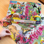 Jigsaw puzzle box featuring a colorful illustration of pollinators and flowers. 100 piece jigsaw puzzle by eeBoo