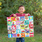 Child holding a colorful alphabet puzzle outdoors with greenery in the background