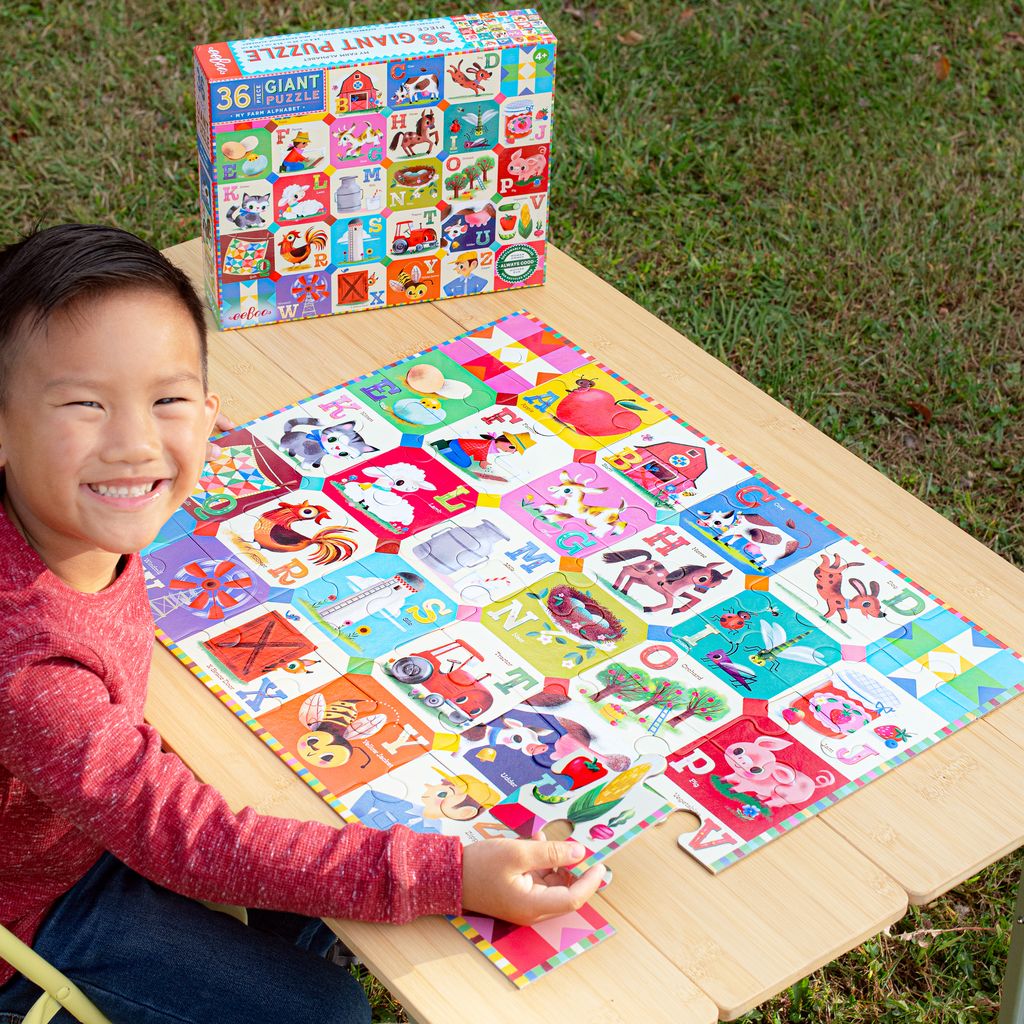 Child playing with a colorful puzzle on a wooden table outdoors
