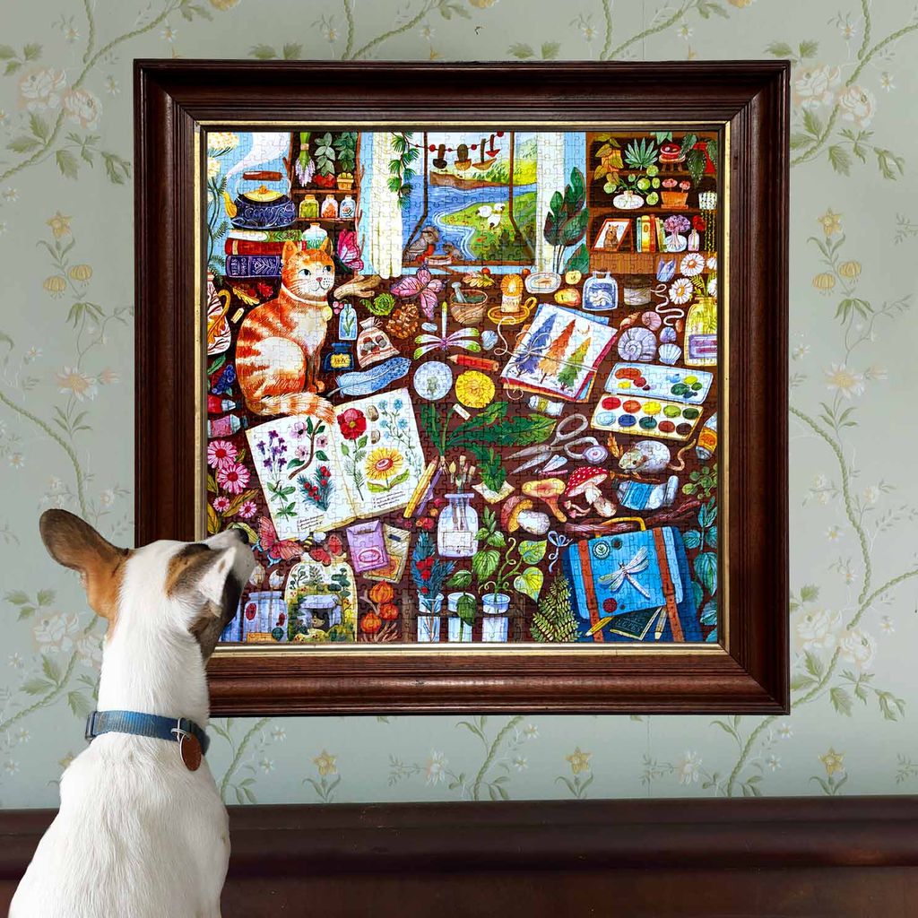 Dog looking at a colorful framed artwork on a wall with floral patterns.