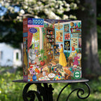 Jigsaw puzzle box with a colorful illustration of a woman in a yellow dress in a room filled with art supplies and decorations, set outdoors.