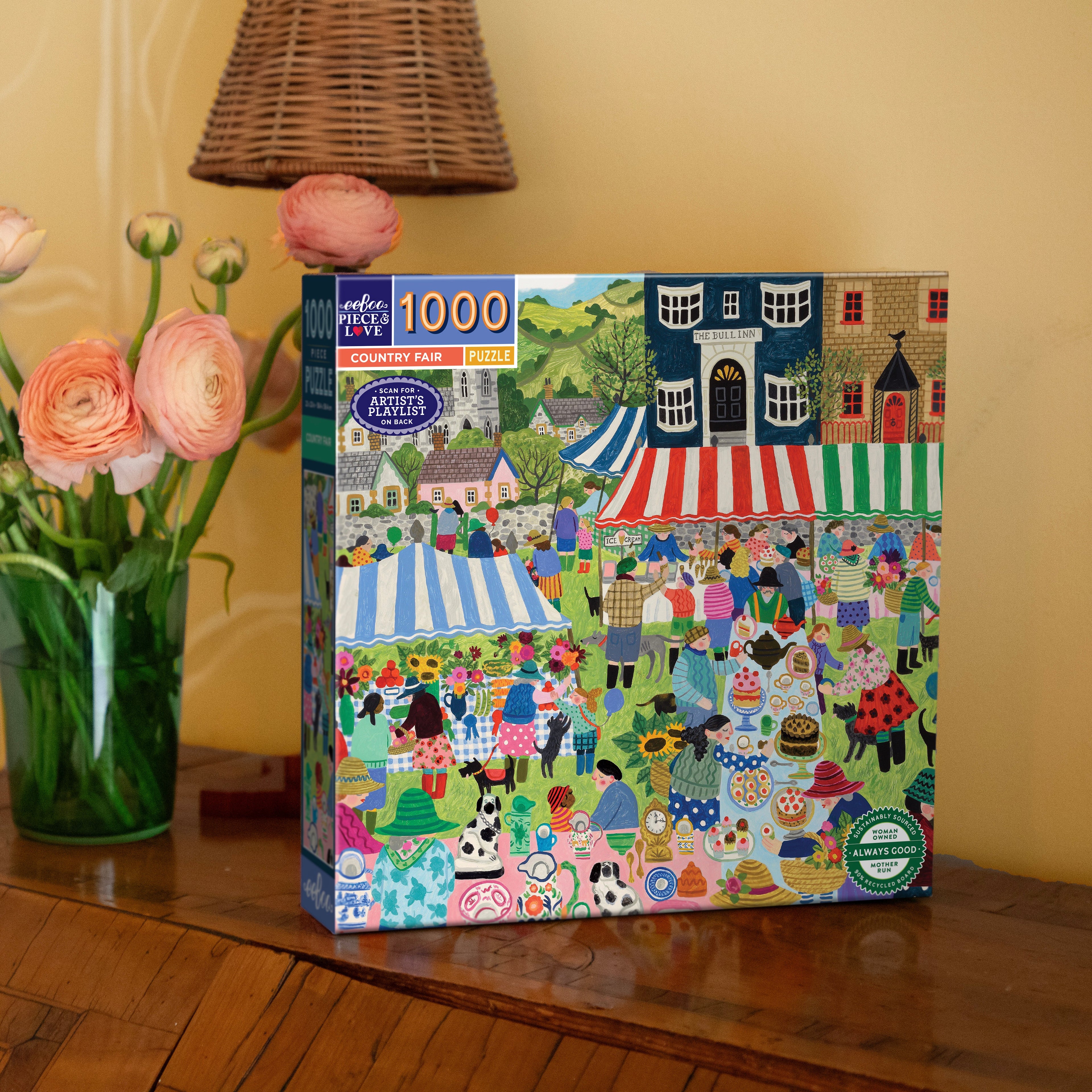 Artist Vanessa Bowman depicts a festive village square filled with tents, crafts & a colorful crowd gathering for the country fair. 1000 Piece Jigsaw Puzzle by eeBoo 