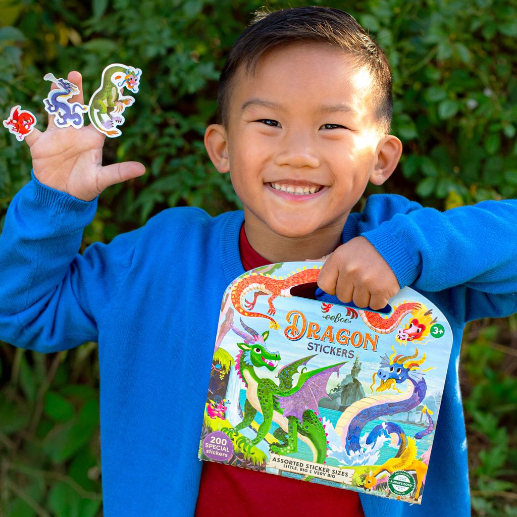 Child holding a pack of dragon stickers with colorful stickers displayed