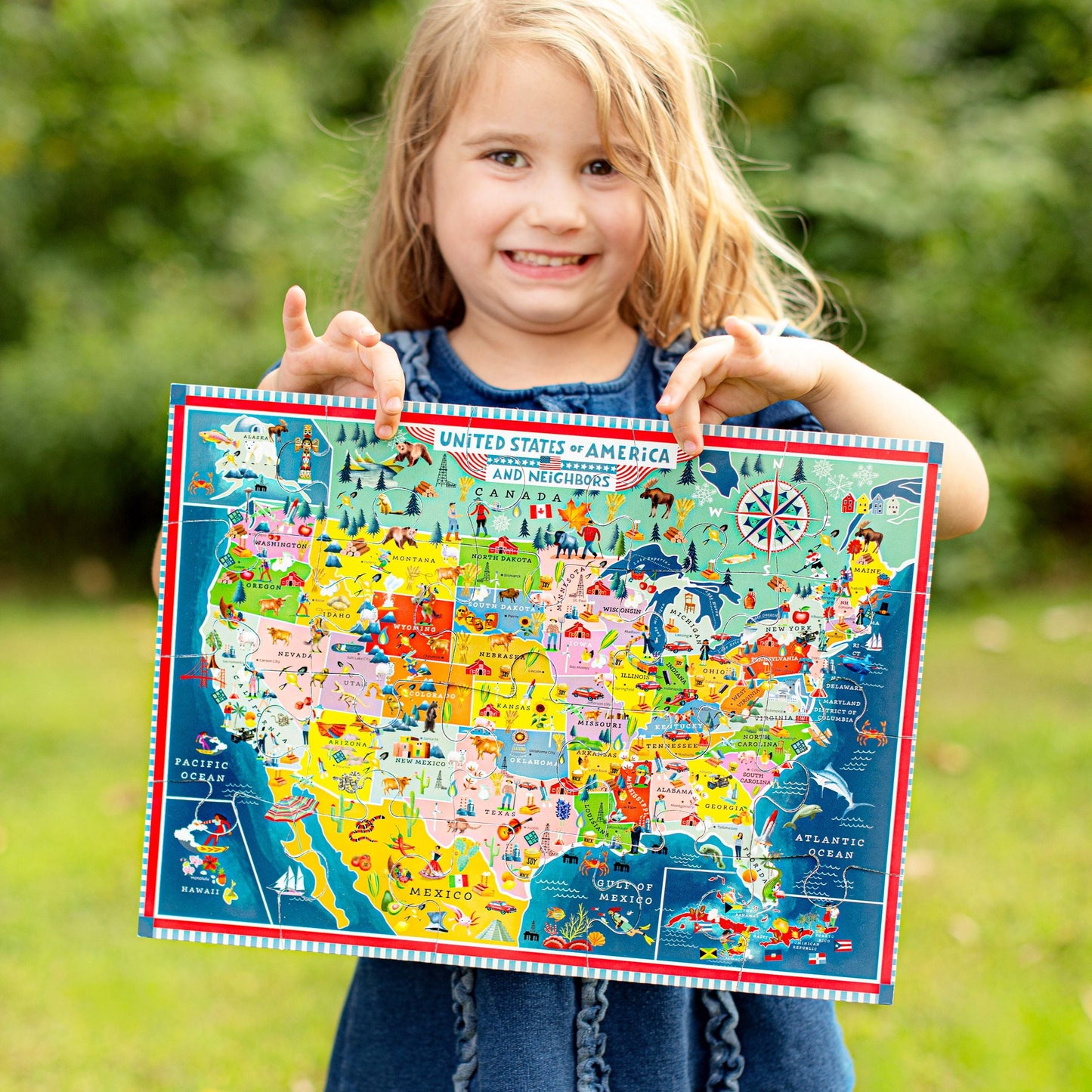 Child holding a colorful map of the United States outdoors. USA Map 20 Piece Puzzle